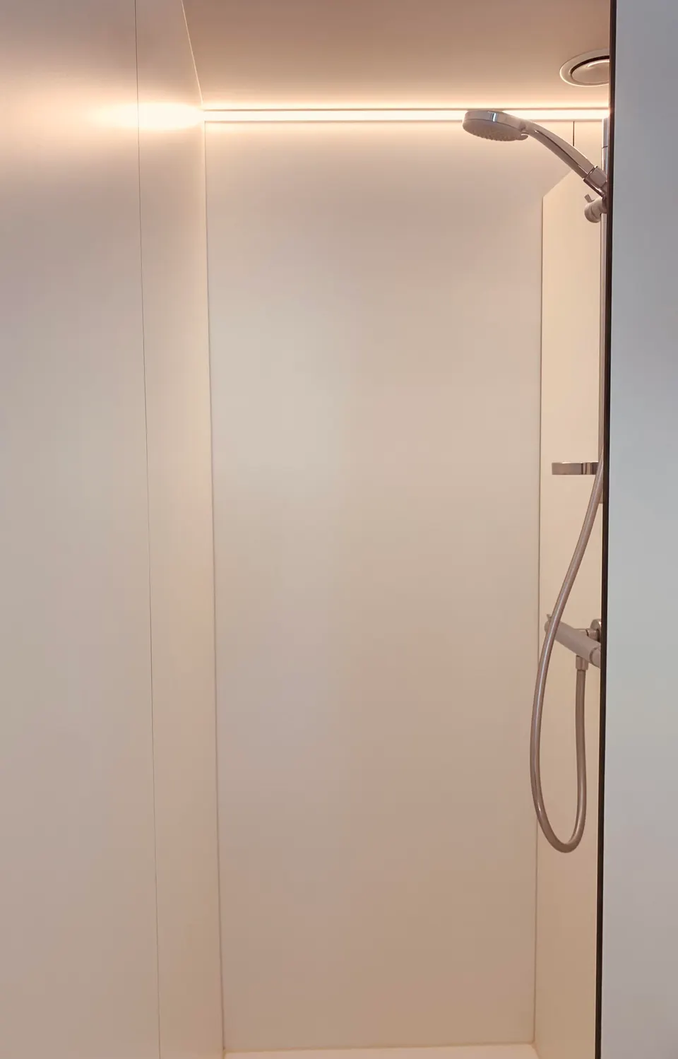 White shower cubicle with a rain shower and a hand shower