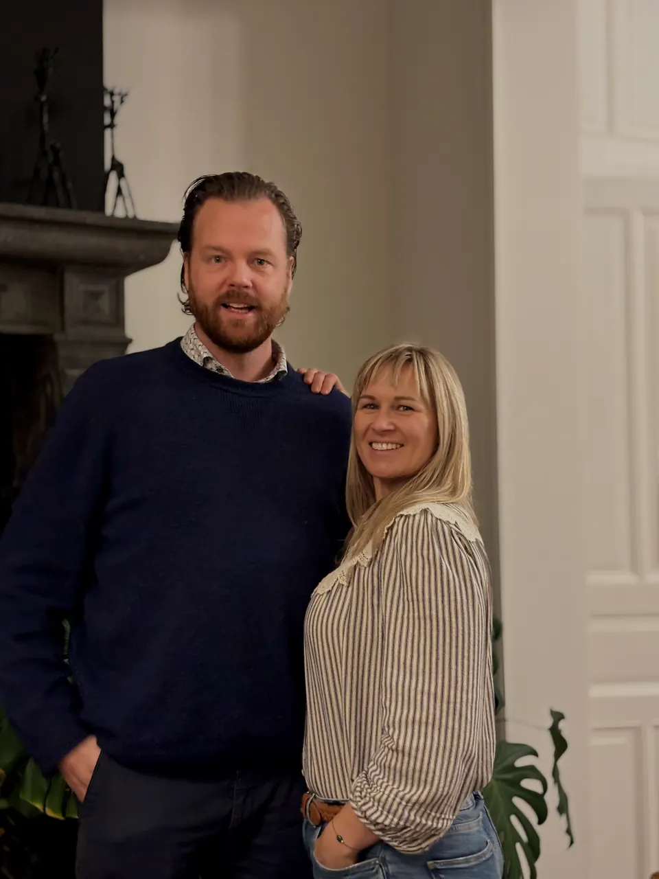 Een man en een vrouw, de gezichten achter Lucilles, glimlachend naast elkaar in een lichte kamer